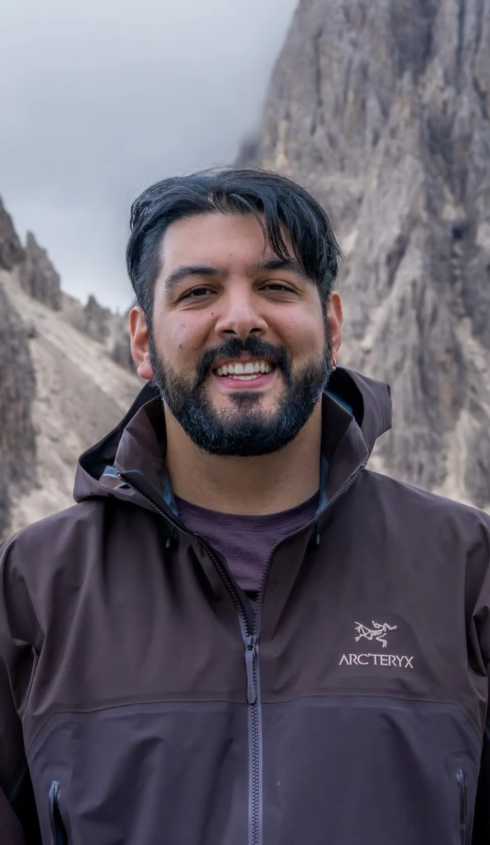 Omid smiling in front of the Cadini di Misurina peaks in the Dolomites